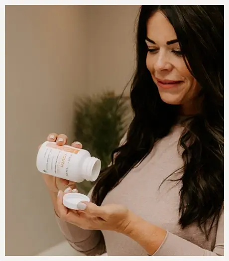 photo of woman pouring a bottle of supplements into her hand
