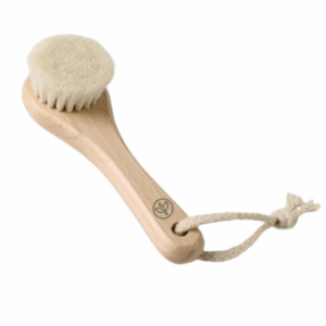 A personal care brush with a smooth wooden handle, soft bristles, and a rope loop for hanging. The handle features a small leaf-shaped logo, indicating eco-friendly design. Suitable for dry brushing or exfoliation.