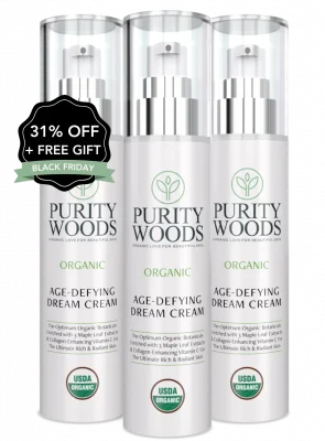Three bottles of Purity Woods Age-Defying Dream Cream, each labeled with organic skincare claims and the USDA Organic seal. Product highlights include maple leaf extract and encapsulated vitamins C and E for radiant skin. A promotional badge on the leftmost bottle reads "31% OFF + FREE GIFT" and "BLACK FRIDAY."